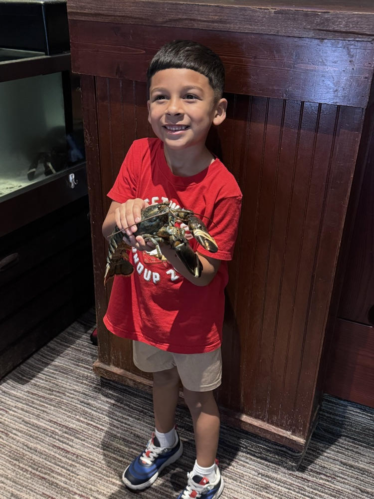A student holding a lobster in the restaurant 