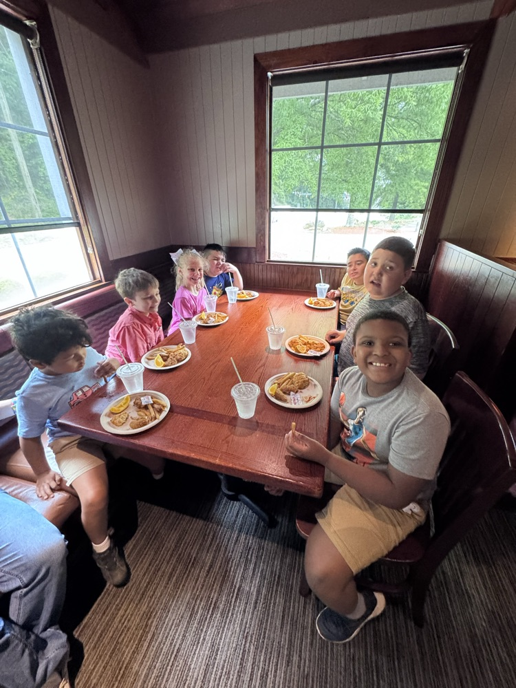 A group of students sitting on the table and enjoying their lunch 