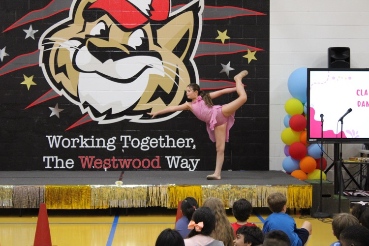 A student doing a dance/gymnastics routine on stage 