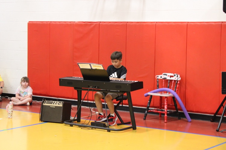 A student playing the piano during talent show 