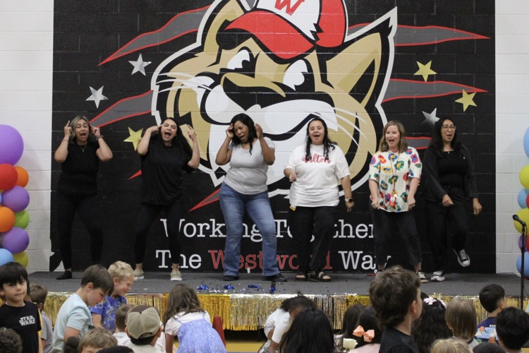 Five teachers dancing on stage 