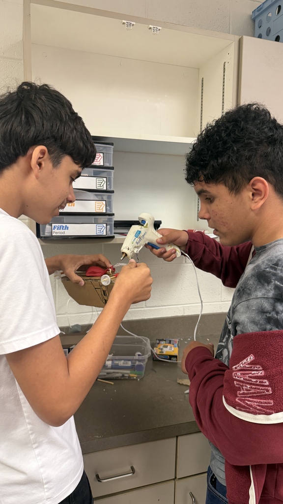 2 students gluing car together