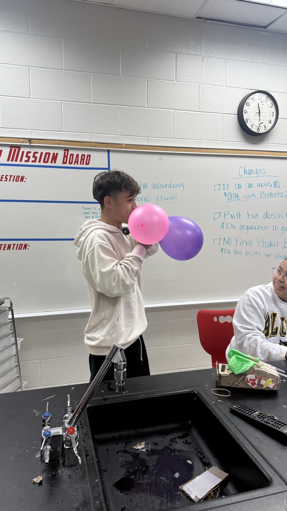 student blowing up balloons for balloon car
