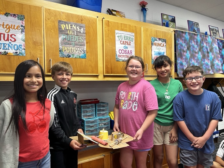 Students holding the simple machine that they created as a team