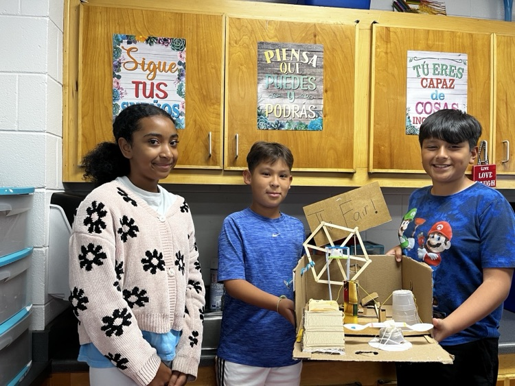 Students holding the simple machine that they created as a team