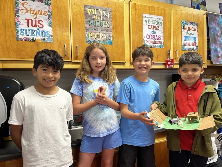 Students holding the simple machine that they created as a team