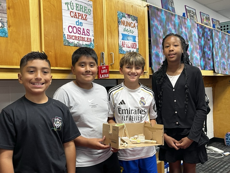 Students holding the simple machine that they created as a team