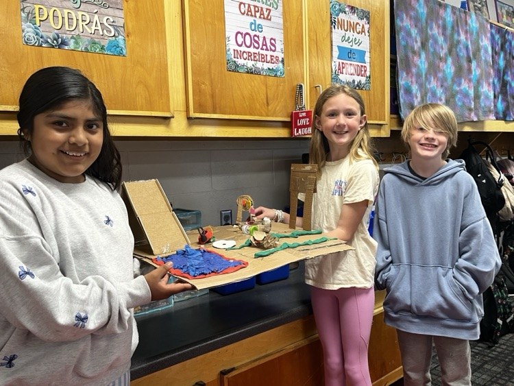 Students holding the simple machine that they created as a team