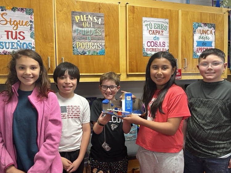 Students holding the simple machine that they created as a team