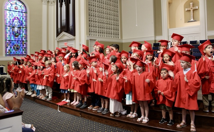 Pre K classes singing a song on the stage at graduation 