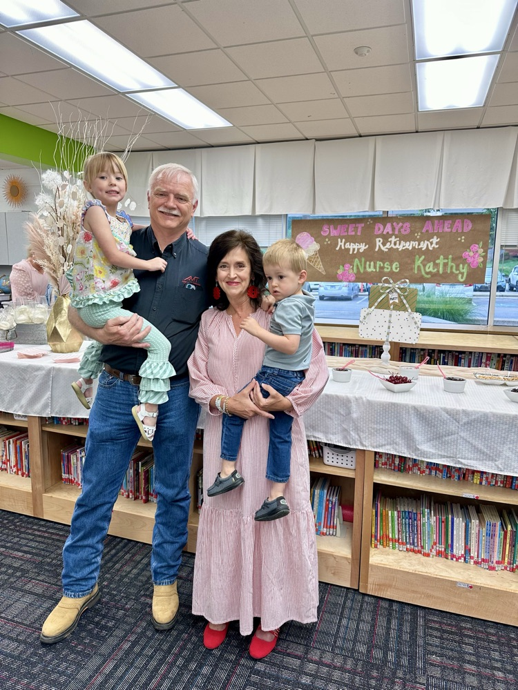 Nurse Kathy with her husband and two grandkids in the Media Center during her retirement party