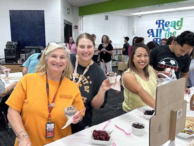 Three teachers getting toppings for the ice cream sundaes 