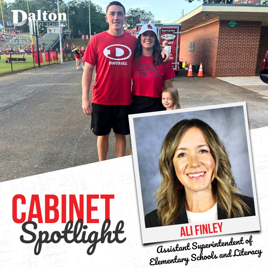 A Dalton Public Schools “Cabinet Spotlight” graphic highlights Ali Finley, Assistant Superintendent of Elementary Schools and Literacy. The design features a candid photo of Ali standing with a student athlete and a young child at a football stadium, all wearing Dalton-themed apparel. An inset professional headshot of Ali appears in a tilted frame on the right side. The graphic includes the Dalton Public Schools logo, the title “Cabinet Spotlight,” Ali Finley’s name, and her position within the district.