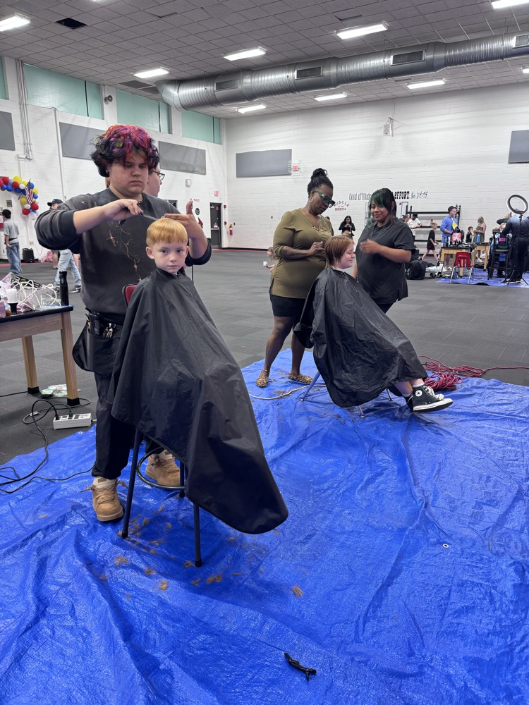 Students getting a haircut in the gym 