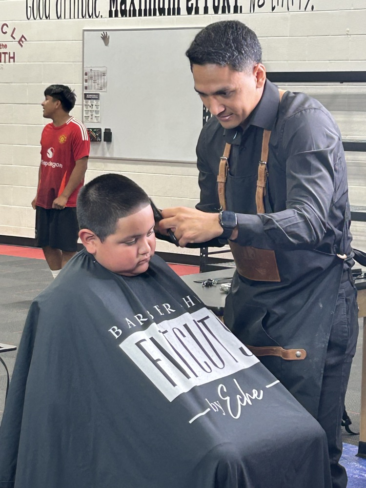 A student getting a haircut in the gym 