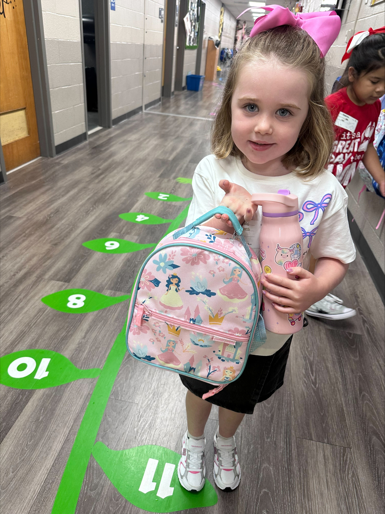 a pre-k student unpacking her backpack for school