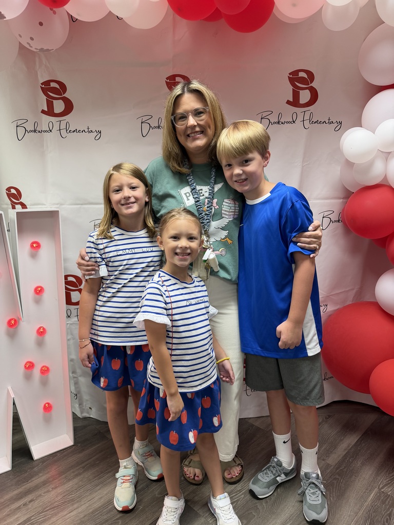 a teacher and her three brookwood children smiling for a picture