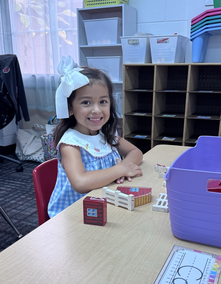 A kindergarten student playing at her table 