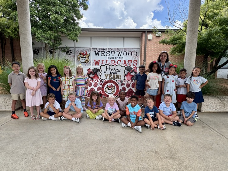 Mrs. Santiago’s class  taking a picture outside in front of the Westwood yard sign 