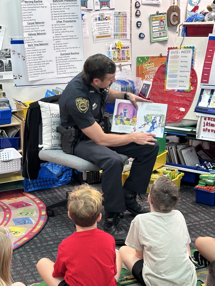 Officer Jenkins showing the book illustrations to the students 