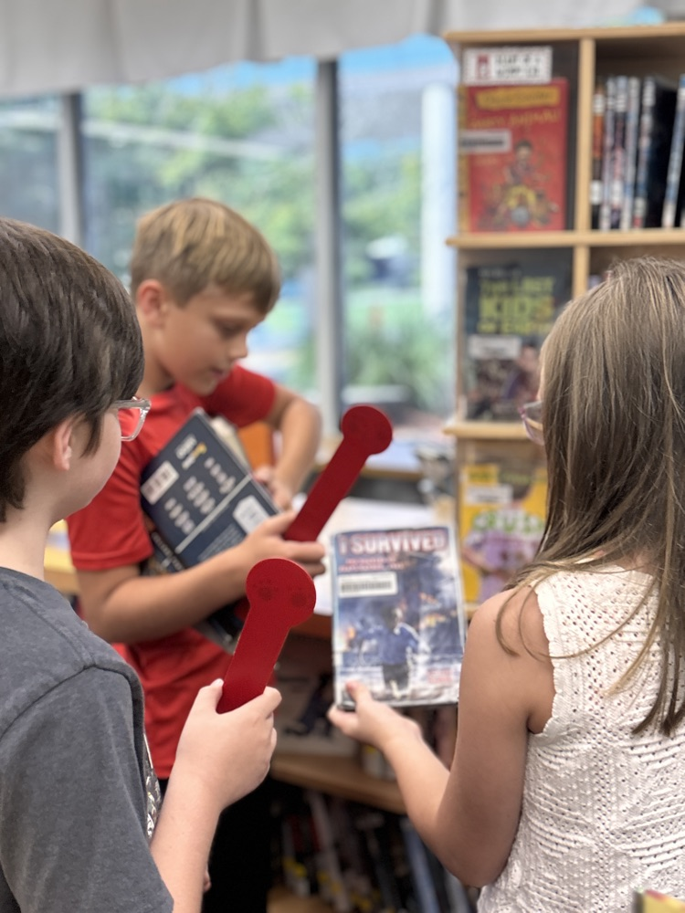 Students holding their books before checking out