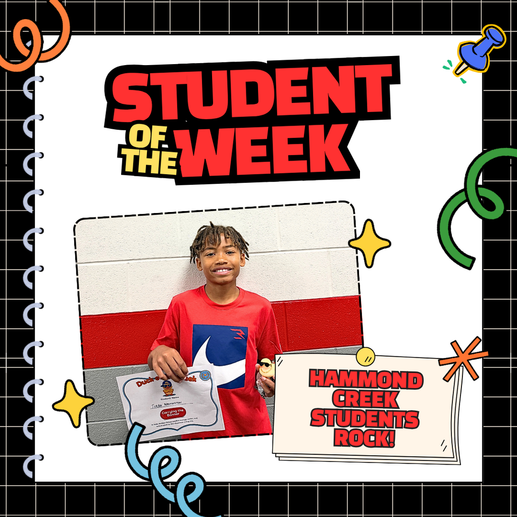 Student stands in a school hallway holding a Duck of the Week certificate and a small yellow duck award. The certificate recognizes the student for Expecting Excellence. The student is being celebrated for bringing positive energy, school spirit, and encouragement to the classroom.
