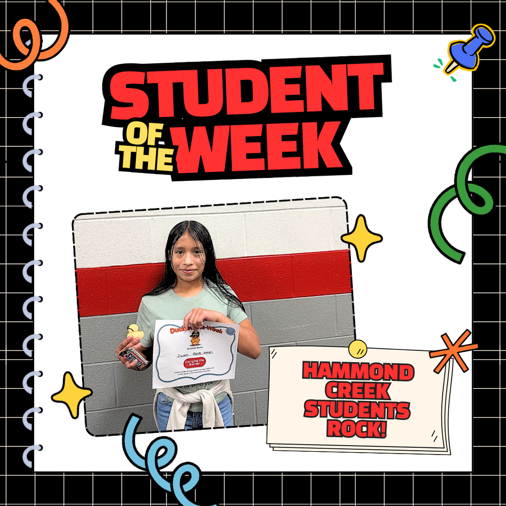 Student stands in a school hallway holding a Duck of the Week certificate and a small yellow duck award. The certificate recognizes the student for Expecting Excellence. The student is being celebrated for bringing positive energy, school spirit, and encouragement to the classroom.