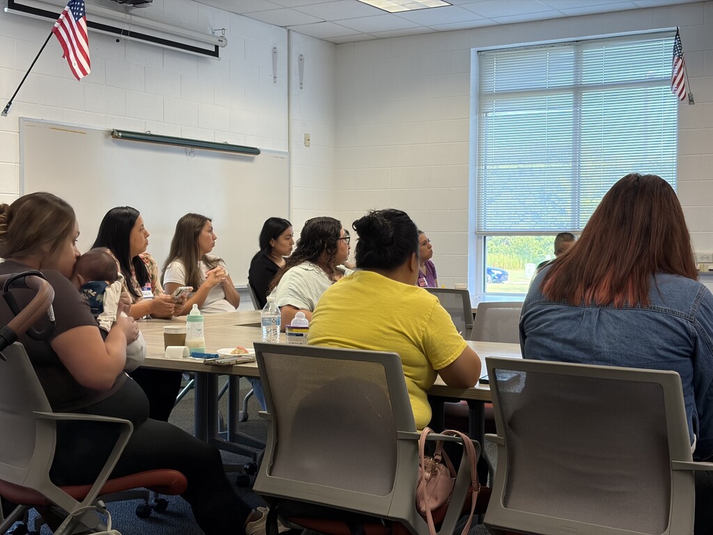 Attendees sitting around tables listening during a meeting or presentation.