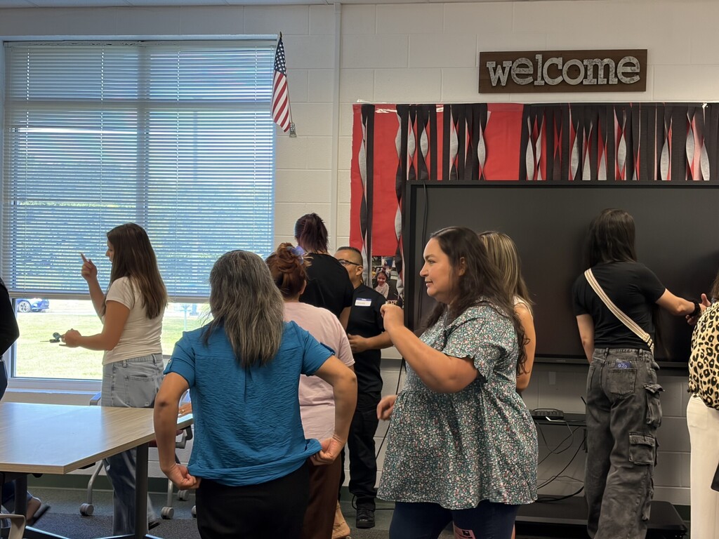 Adults engaging in an interactive group activity inside a classroom.