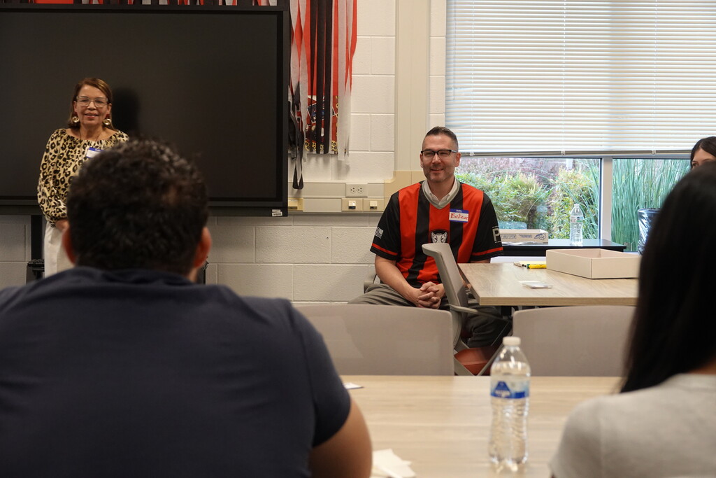 Speaker standing at the front of a room during a group presentation.