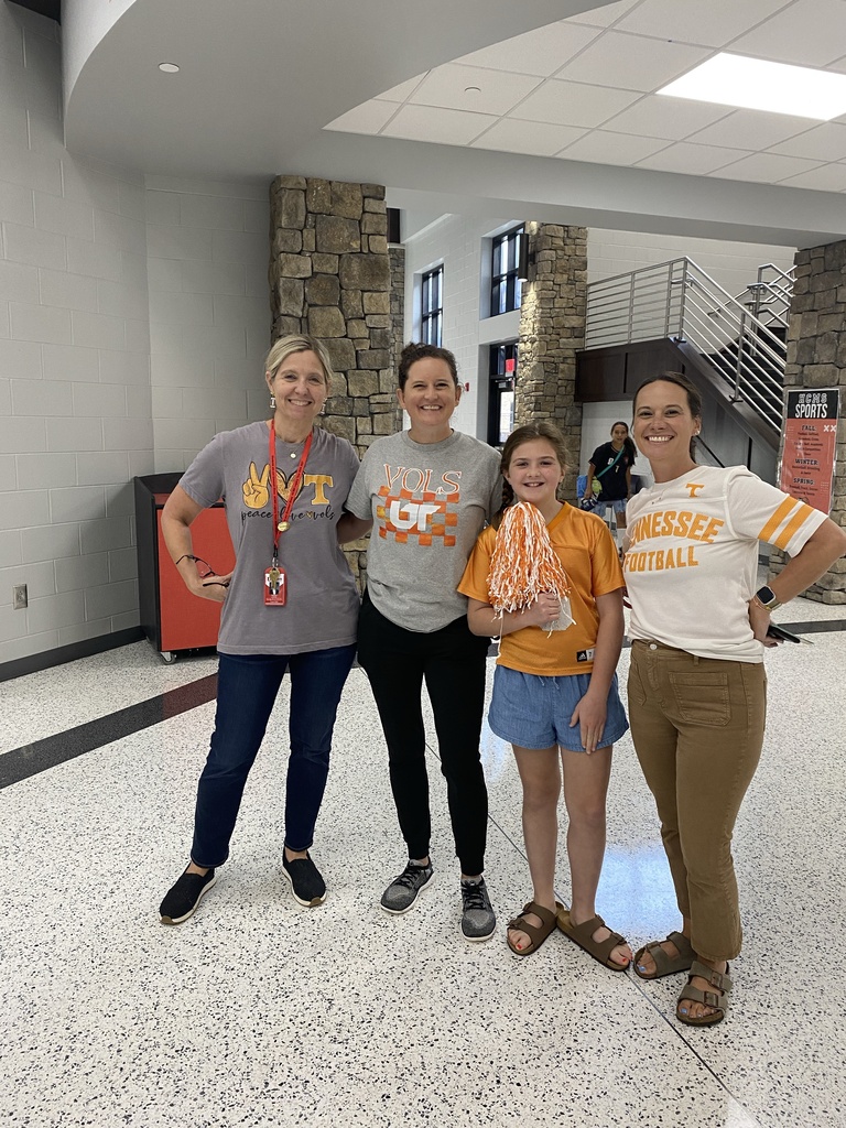 Group photo of HCMS staff members proudly representing the Tennessee Volunteers during Team Spirit Day. Staff members are wearing orange Tennessee apparel and posing together to celebrate school spirit, football season, and their favorite team.