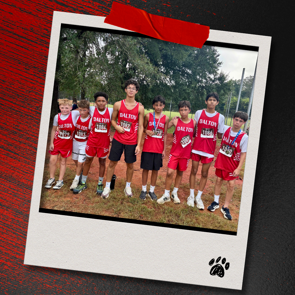 Eight Dalton Middle boys cross country runners in red uniforms pose together after the race, with two runners wearing medals. The photo is displayed in a taped Polaroid-style frame on a textured red-and-black background with a paw print accent.