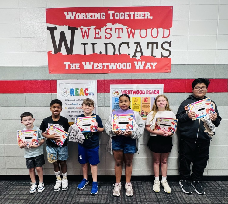 Six elementary students standing in a row holding award certificates under a banner that reads "Working Together, Westwood Wildcats, The Westwood Way."