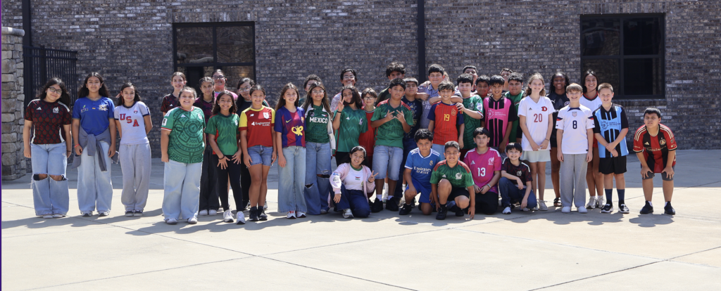 Group photo of HCMS students dressed in soccer jerseys and team apparel for Soccer Jersey Day. The event marked the beginning of the school's Hispanic Heritage Month celebration.