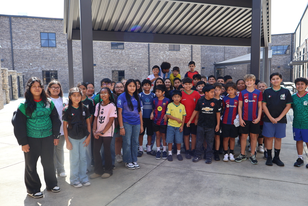 Group photo of HCMS students dressed in soccer jerseys and team apparel for Soccer Jersey Day. The event marked the beginning of the school's Hispanic Heritage Month celebration.
