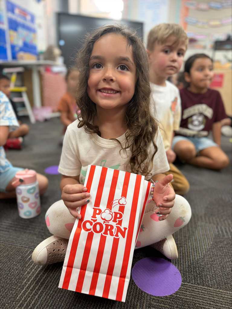 student smiling with a red striped bag that says popcorn during a lesson about their 5 senses