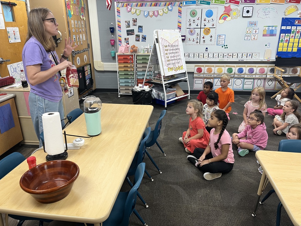 students getting taught by a teacher as she prepares to pop popcorn for their lesson about the 5 senses