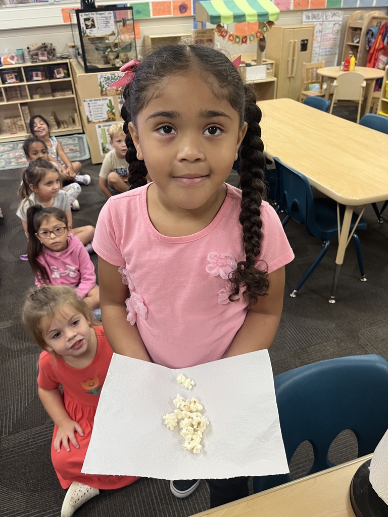 student smiling with a red striped bag that says popcorn during a lesson about their 5 senses