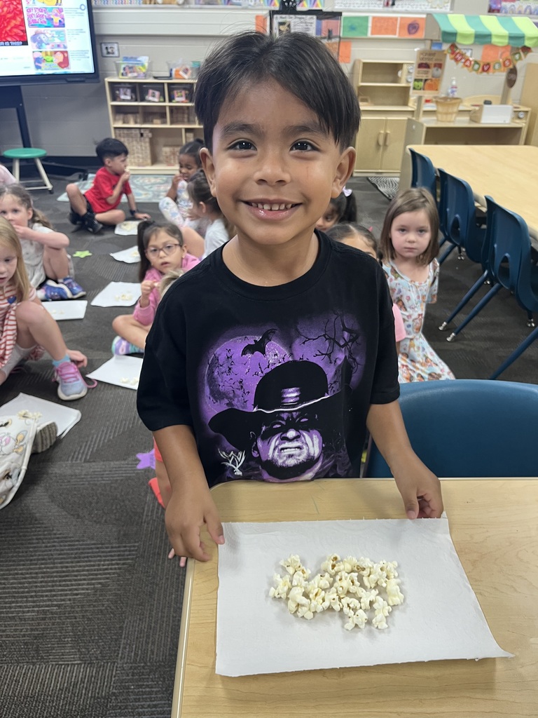 student smiling with a red striped bag that says popcorn during a lesson about their 5 senses