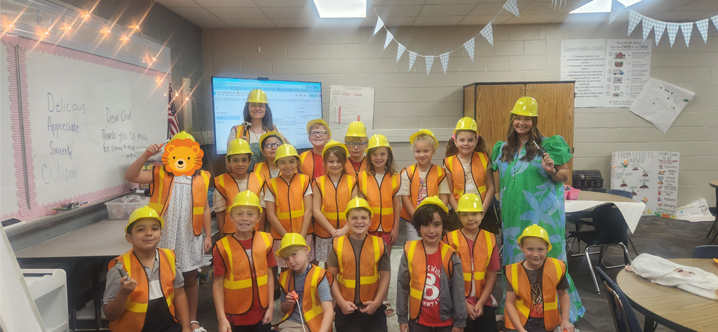 students smiling in a classroom dressed as construction workers