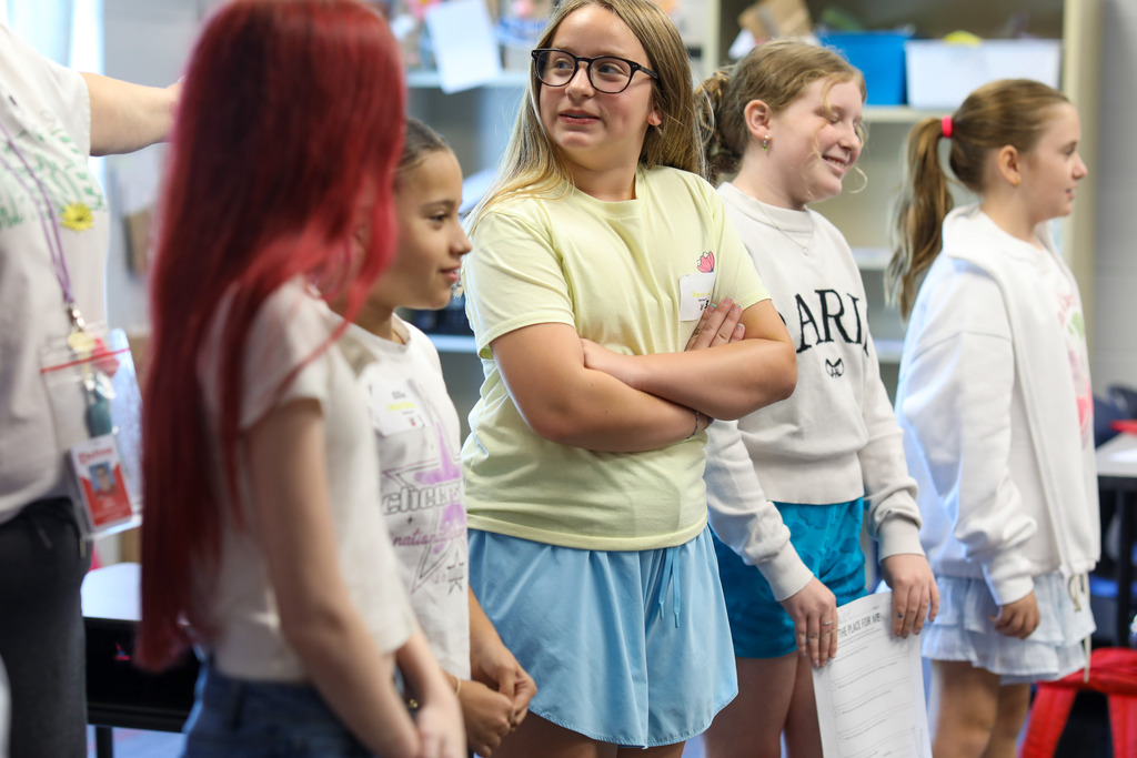 Female students standing together in a line presenting to their class.