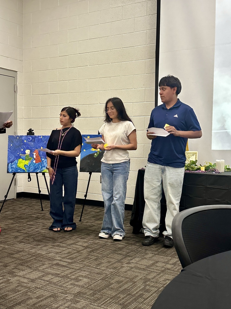 Alt Text: Group photograph of newly inducted French and Spanish Honor Society members holding certificates and candles in front of an Adidas logo backdrop.