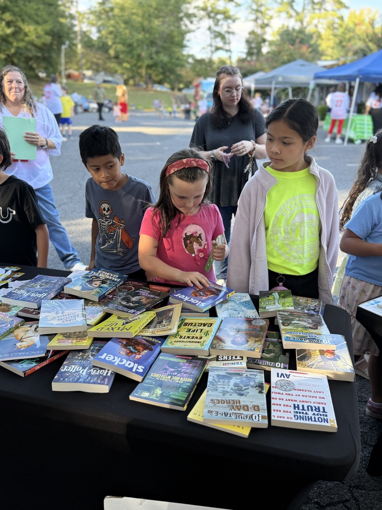 students looking through new, free books donated by dalton Reads at literacy night