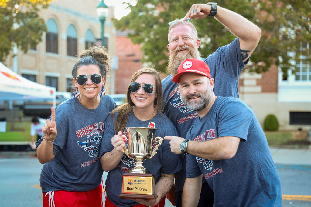 Dalton Public Schools staff posing with the United Way "Best Pit Crew" trophy.