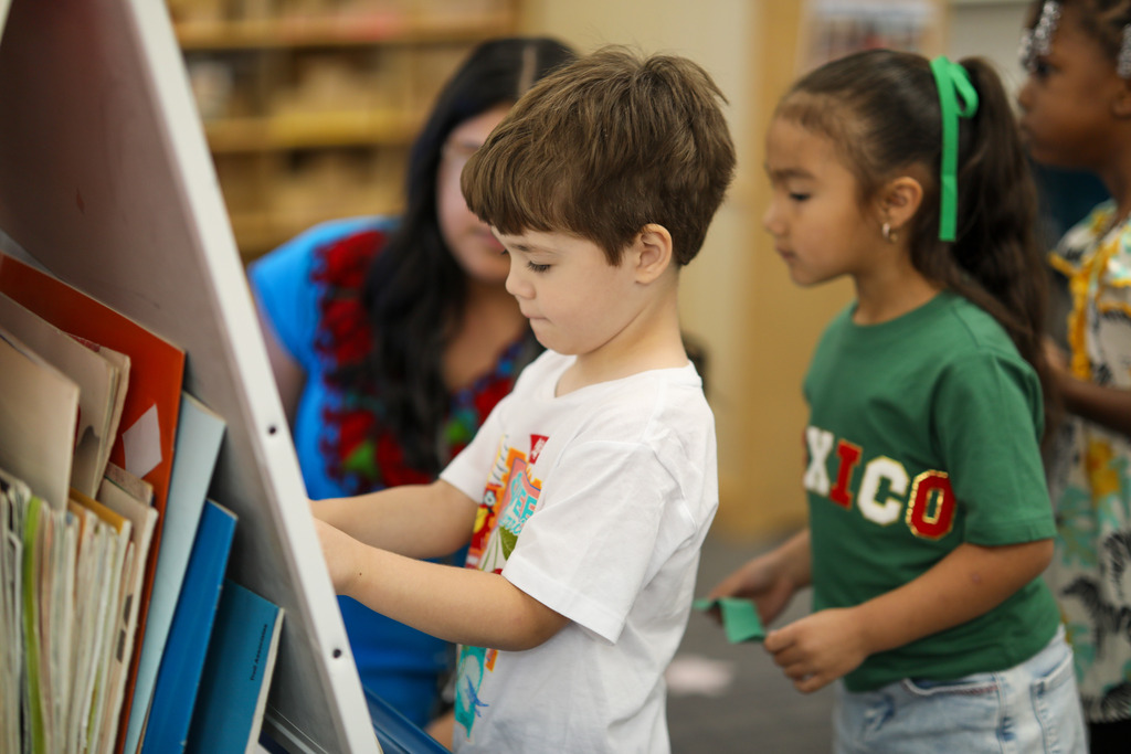 A boy places paper on a flat piñata.