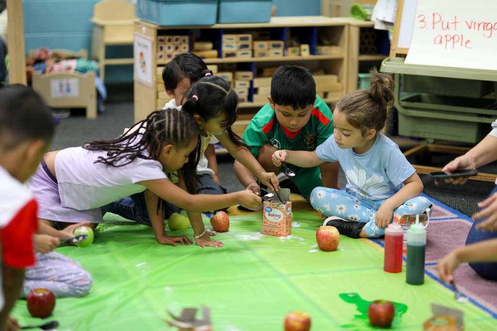 Students work together to add baking soda to their apples.
