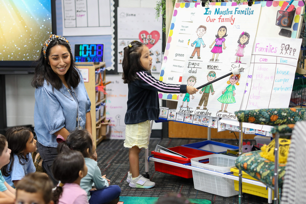 A student points to the family members on the board.