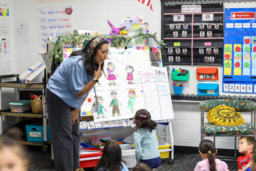 A teacher mouths the pronunciation of a word.