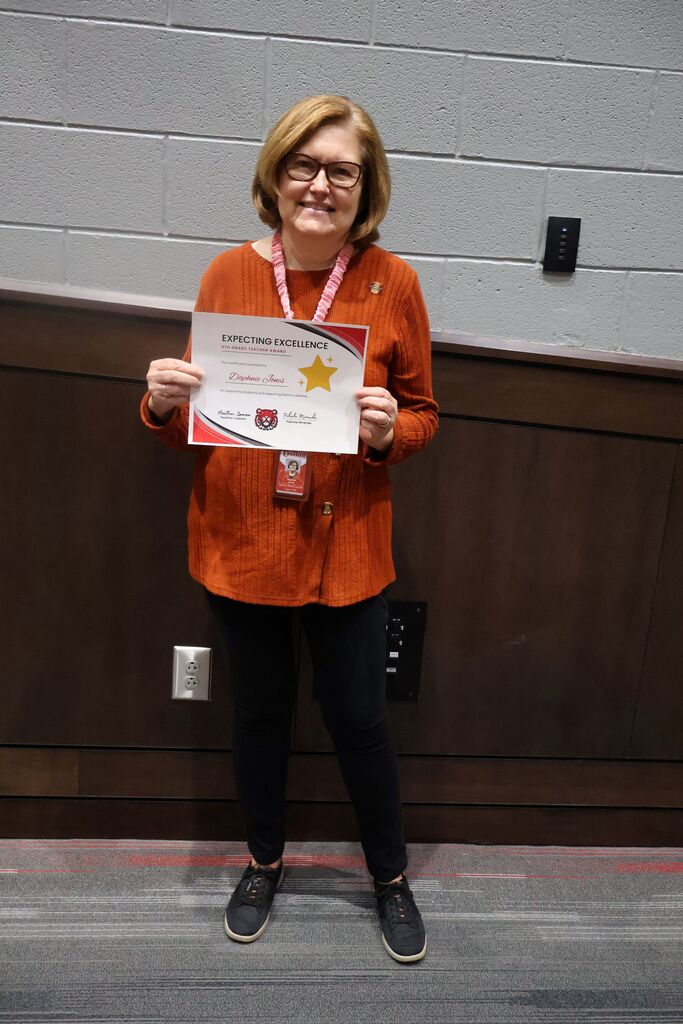 HCMS Teacher of the Quarter holding their award certificate.
