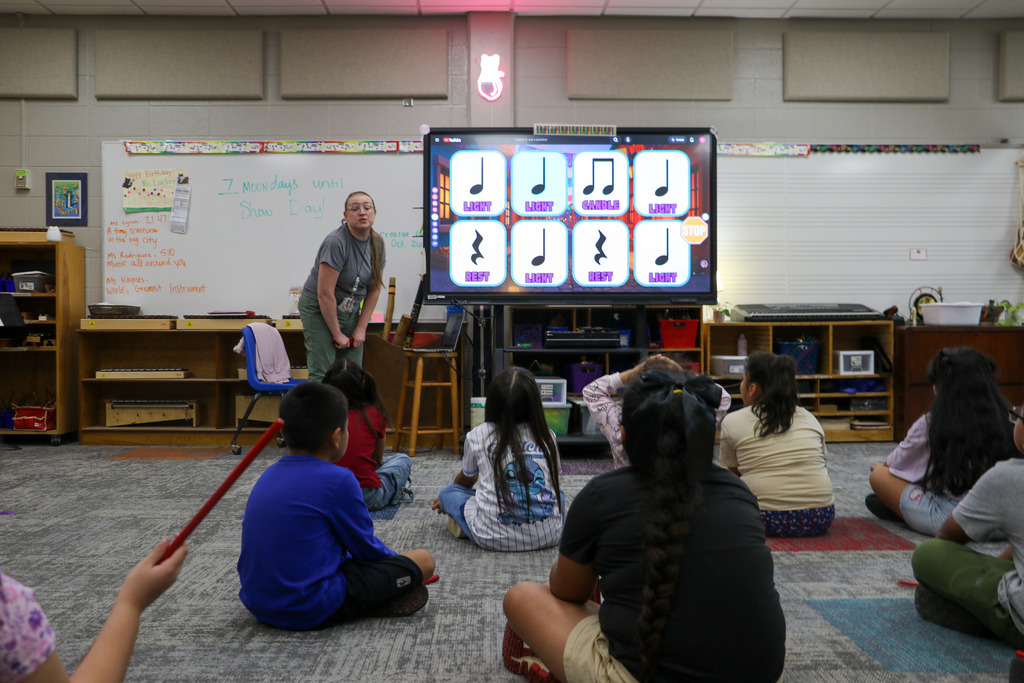Students sit and watch their teacher.